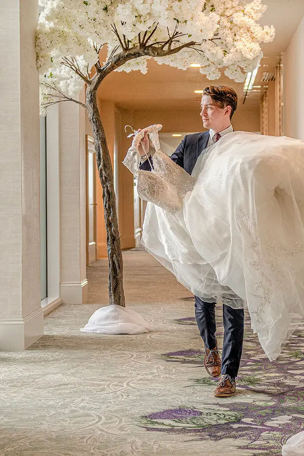 Wedding dress carried through hotel corridor