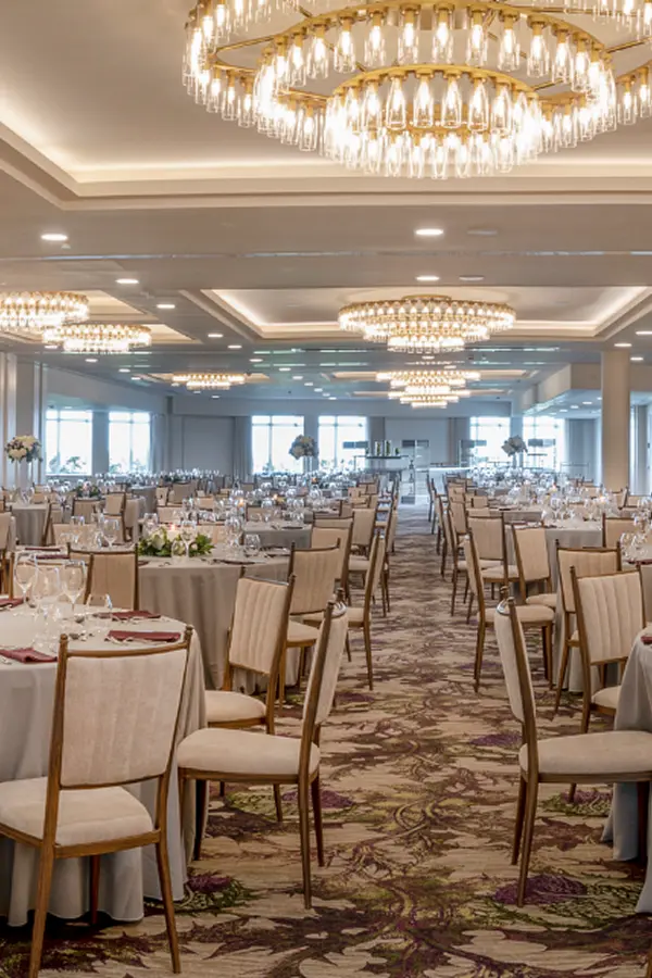 Grand ballroom with gold ring chandeliers and formal dining